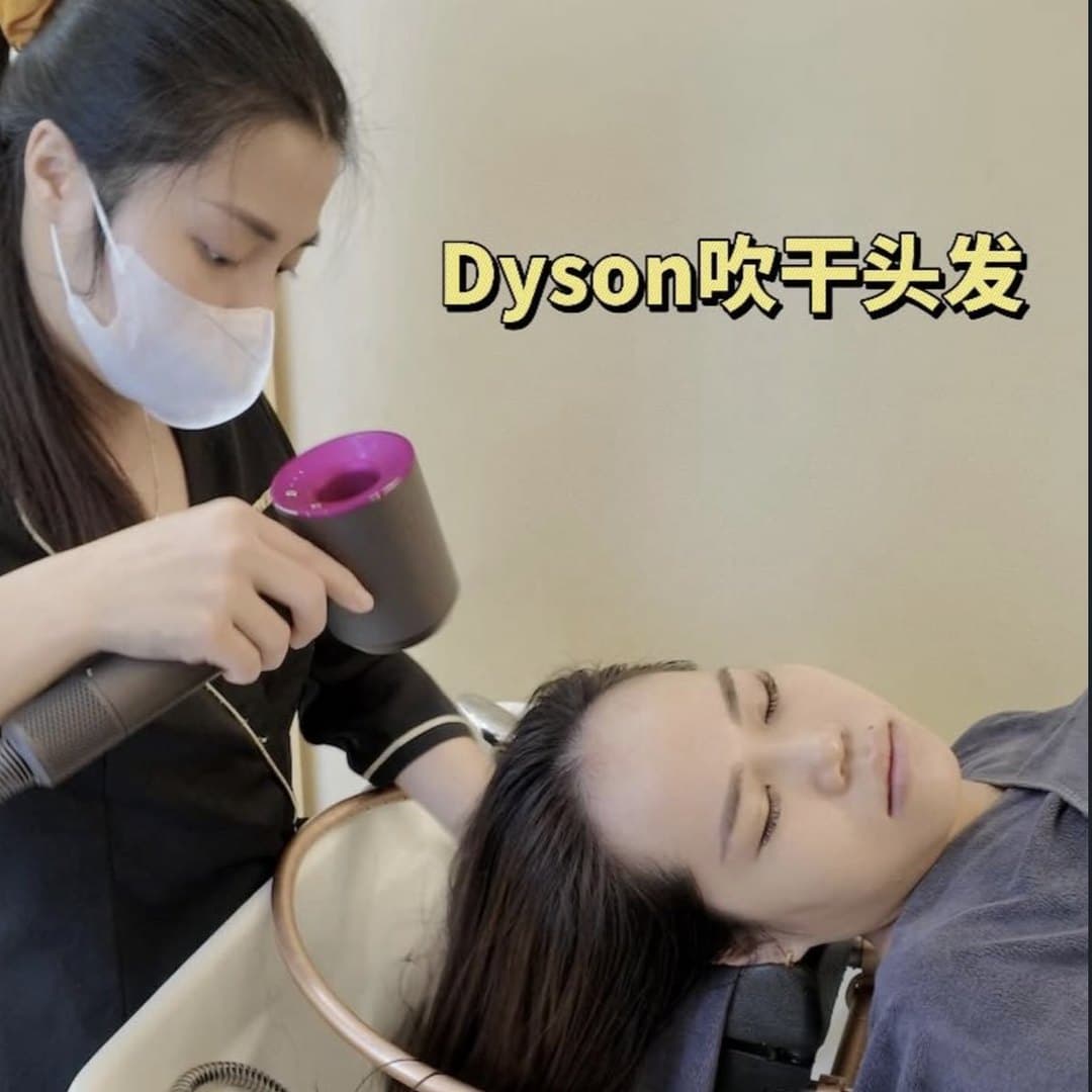 Therapist blow-drying a client’s hair at the head spa basin