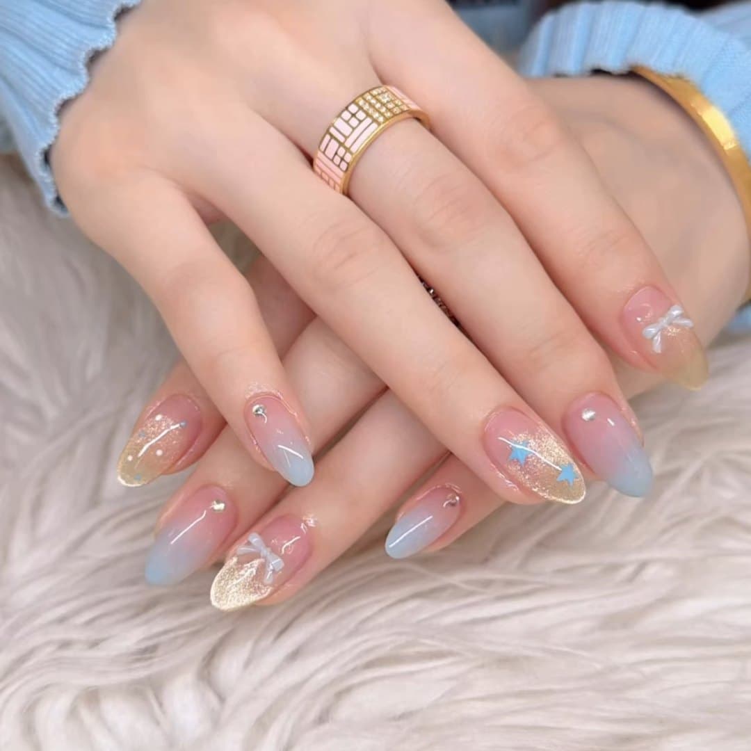 Pastel blue and nude ombre nails finished with gold leaf detail